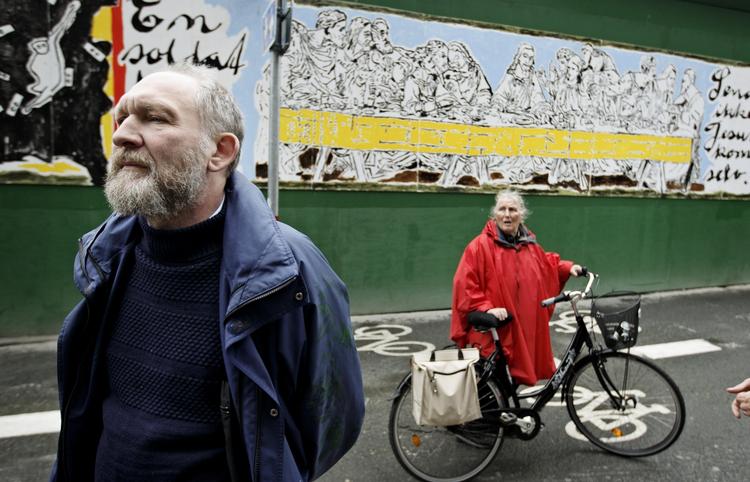 Alvor. Selv om Rådhuspladsens nye maleri har en let og legende stil, er budskabet alvorligt. Her ses kunstneren Kenn André Stilling foran værket. 