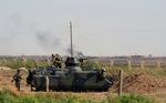 GRÆNSEKONFLIKT. Tyrkisk kampvogn foran grænsen ind til Syrien med den oprørskontrollerede by Tel Abyad i baggrunden. 