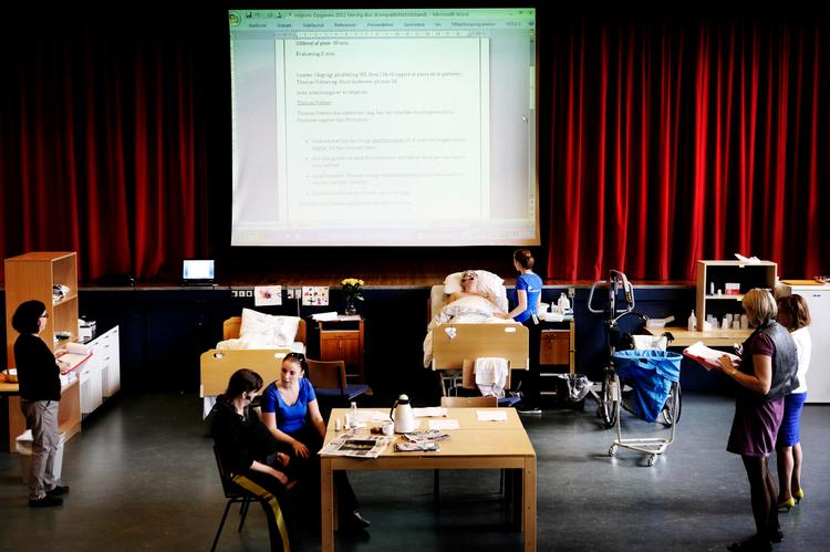 SOSU-DM.  Jeanett Kristensen og Agnethe Grønbech omgivet af opgaver. De vil gerne vise kompleksiteten  i deres fag. 