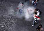OPTØJER. Demonstranter indhylles i tåregas, da de forsøger at fjerne pigtrådsafspærring foran Beiruts regeringskontorer. 