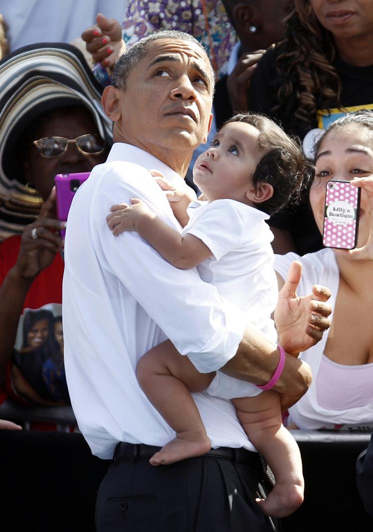 Barnemad. Barack Obama bærer på en baby, mens han forbereder sig til at forlade et valgarrangement i Florida tirsdag. Blot en lille fremgang i målingerne vil gøre ham til storfavorit, men det er usikkert, om den kommer. 