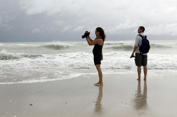 afventende. Turisterne Stephanie og Dan Koch fra Atlantic City på stranden i Miami Beach, hvor de skuer ud over havet, hvorfra Sandy nærmer sig. 