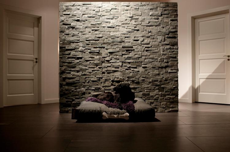 Murværk. I stuen har hunden, Fie, sin plads foran rumdeleren, hvis struktur fremhæves af lys fra oven. 