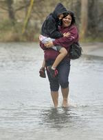 Ann Marie Karavas bærer sin søn Jeffrey Karavas gennem vandmasserne nær deres hjem i East Haven. 