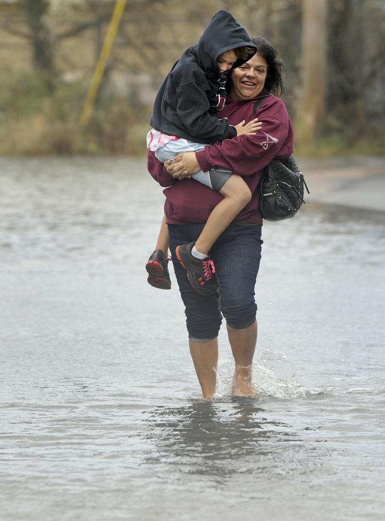 Ann Marie Karavas bærer sin søn Jeffrey Karavas gennem vandmasserne nær deres hjem i East Haven. 