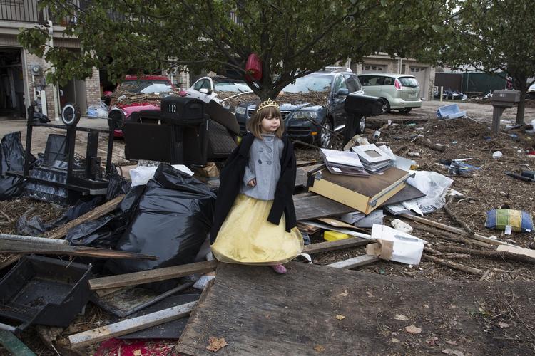 Lisa Kravchenko fra Staten Island står i sit Halloween-kostume mellem resterne af ødelagte huse. 