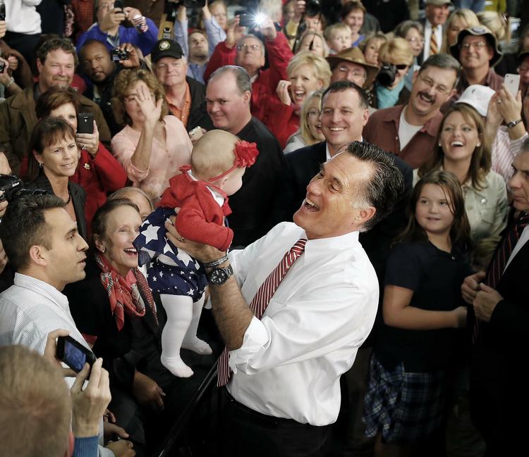 Mitt Romney er heller ikke bleg for at holde en fremmed baby. Her løfter et barn under et vælgermøde i Doswell, Virginia. 
