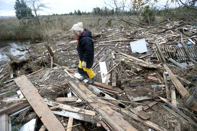 STORMSKADER. Tricia Burke ved affald, der er endt på hendes grund i New Jersey under stormen Sandy. 