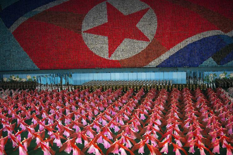 Massegymnastik. I Nordkorea er der tradition for de såkaldte Arirang-fester, hvor op mod hundredetusinder ofte medvirker. Her er dansere i gang i forgrunde, mens andre i baggrunden holder farvede kort op, der tilsammen former landets flag. 