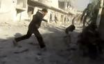 Oprør. En mand løber væk fra et område, der bliver bombet i Houla i Syrien. Billedet er fra et videoklip, der er blevet verificeret af nyhedsbureauet AP. 