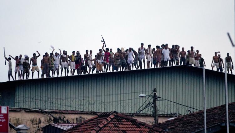 OPTØJER. Indsatte på fængslelstaget i Colombo viftede med våben under deres oprør. 