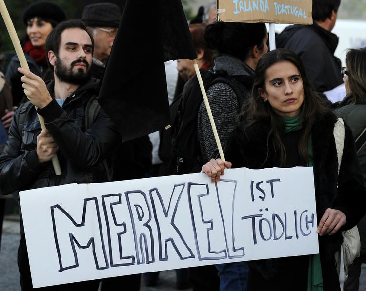 uvelkommen. Vrede portugisere fotograferet i mandags, hvor de protesterede mod den tyske kansler, Angela Merkels, besøg. 