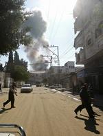 Dækning. Indbyggere i Gaza By løber, mens en bombe falder i baggrunden. 