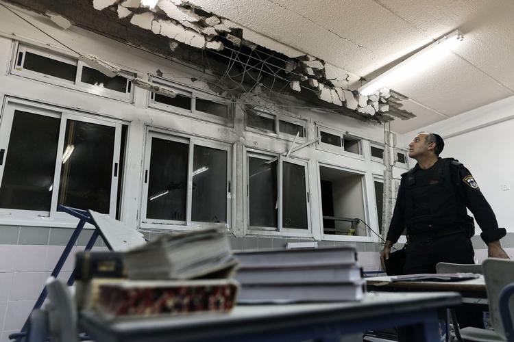BOMBERAMT. Israelsk politibetjent beser skaderne i et klasseværelse, der er blevet ramt af en raket, affyret fra Gaza. 