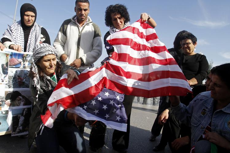 DEMONSTRATION. Palæstinensere brænder det amerikanske flag under protester mod udenrigsminister Hillary Clintons møde med den palæstinensiske præsident Mahmoud Abbas i Ramallah 