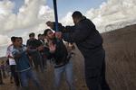 GRÆNSEKONTROL. Hamasbetjent holder palæstinensere væk fra grænsehegnet ind mod Israel ved Khan Younis i Gaza. 