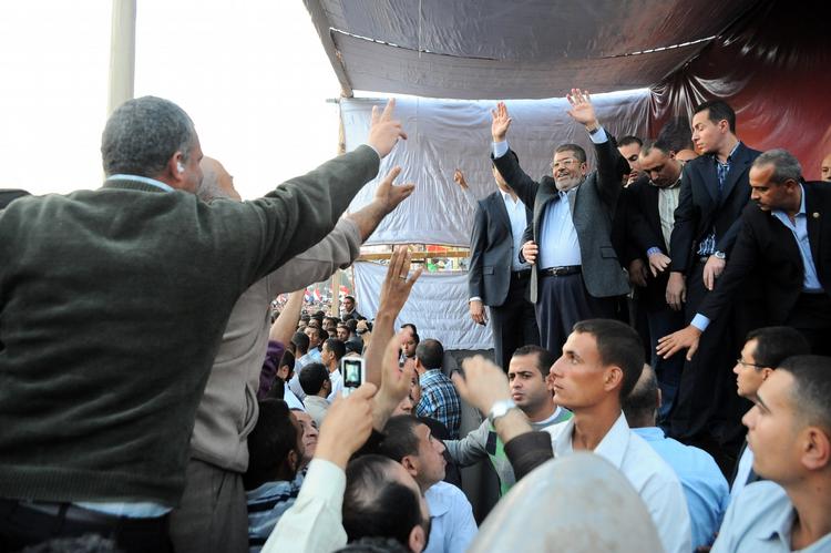 Hyldest. Præsident Mohammed Morsi vinker til sine tilhængerer i dag i Kairo. 