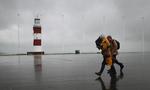 MODVIND. Spadserende i Plymouth trodser vinden og vandet. 