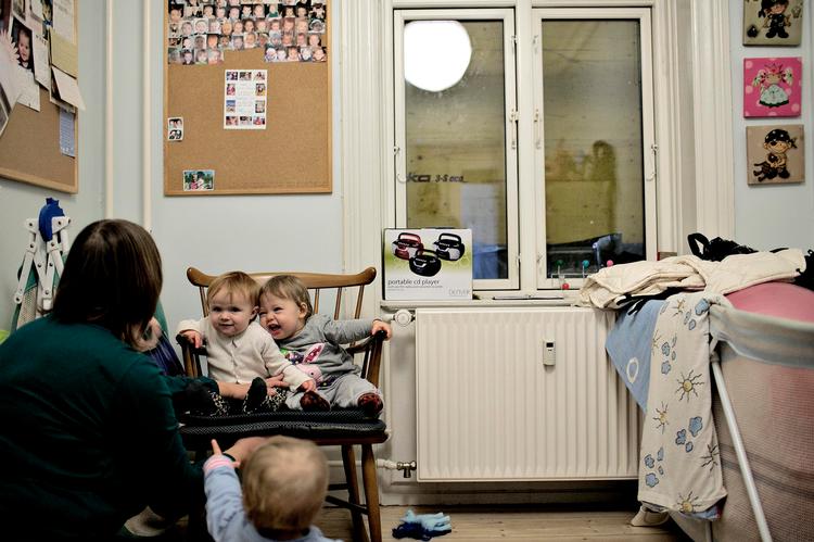 Mørklægning. Der er sat træplader op foran vinduerne for at dæmpe støjen. Der kommer derfor hverken dagslys eller frisk luft ind til de syv små børn, der passes i lejligheden. 