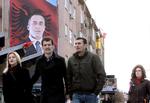 Folkehelt. Fodgængere i Kosovas hovedstad, Pristina, passerer et stort billede af Ramush Haradinaj. 