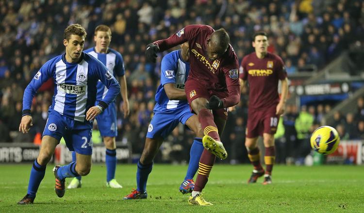 sløjt. Manchester Citys Mario Balotelli scorer holdets første mål i kampen mod Wigan. 