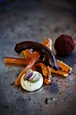 Rustikt. Hakkede appelsiner og mandler samles til en grov marcipan og dyppers herefter i tempereret chokolade. 