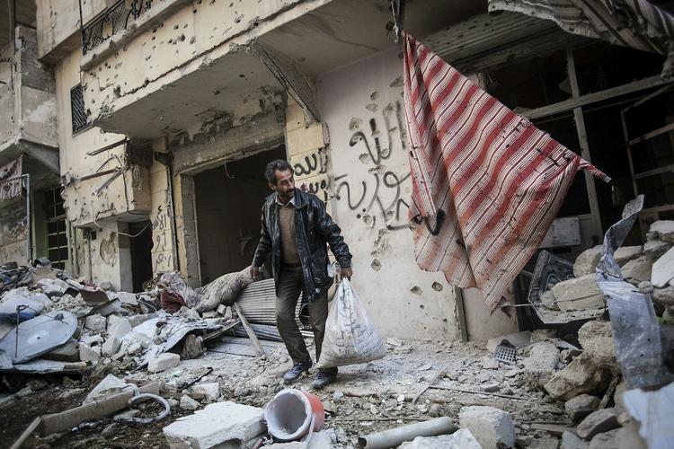 Krig. En mand leder efter sine ejendele i ruinerne efter kampe i byen Aleppo. 