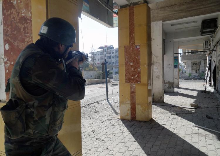 OPRØR. Dette foto fra det oficielle nyhedsbureau Sana viser angiveligt en regeringssoldat, der skyder mod oprørere i Daraya-forstaden i Damaskus tidligere på måneden. 