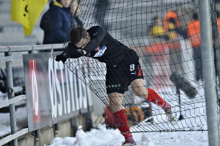 KØLIGT. Sneen var ryddet fra banen, men omkransede det grønne græstæppe, så Petter Andersson fik kolde fødder. 