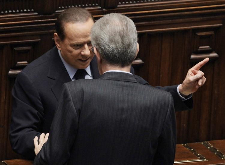 premierministre. Silvio Berlusconi taler med Mario Monti, der står med ryggen til kameraet. 