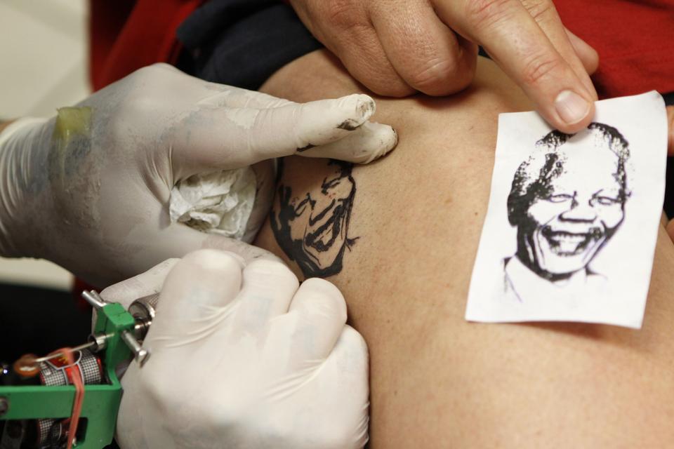 Nelson Mandelas popularitet manifesterer sig også i form af tatoveringer af hans karakteristiske ansigt, som her på en tilhænger før Mandelas 95-års fødselsdag i år. 