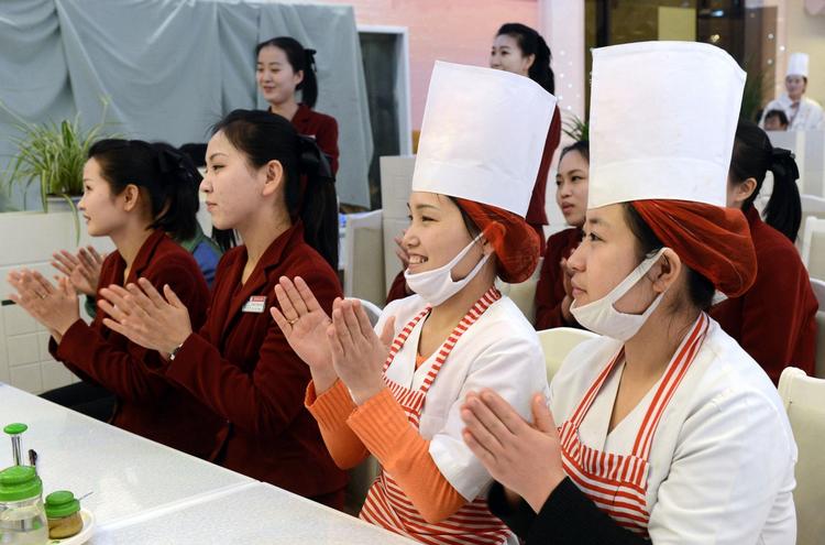 Affyring. Ansatte på en nordkoreansk restaurant klapper troligt af opsendelsen af raketten. 