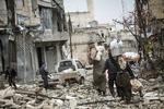 STRID. Indbyggere i Aleppo går gennem gade, hvis huse er voldsomt beskadigede af kampe mellem optørere og regeringstropper. 