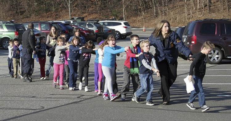 Evakuering. Politiet i Connecticut eskorterer børn ud af Sandy Hook Skolen i Newtown. 