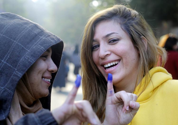 Vælgere. To egyptere har blæk på deres fingre, hvilket viser, at de har stemt. 