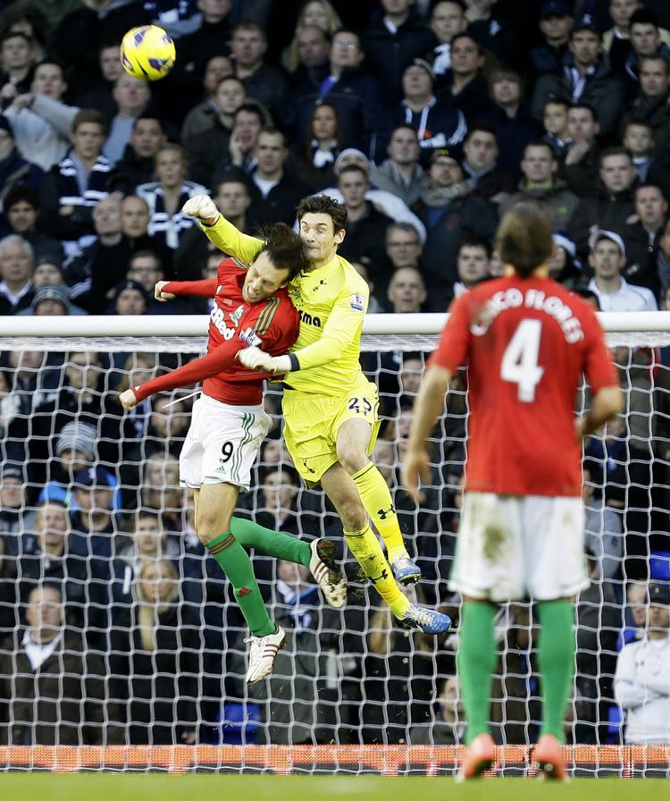 kampstop. Tottenhams målmand  Hugo Lloris (i gult) bokser både bolden og Swanseas Michu væk, så spanieren blev liggende på græsset. 