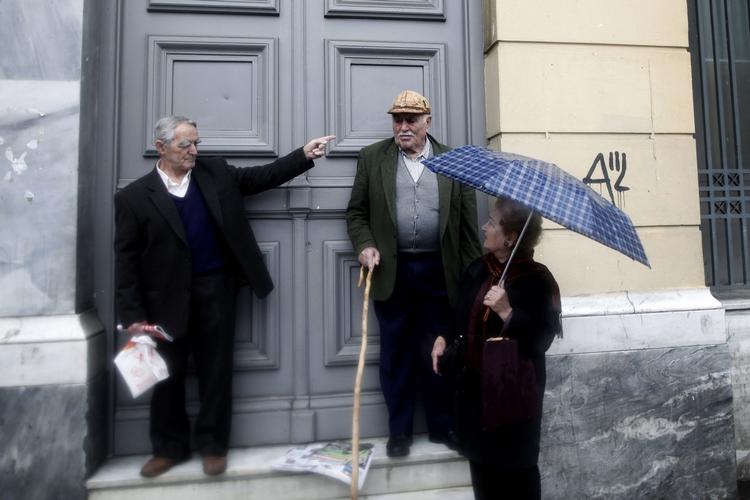 Opmuntring. Grækere får sig en sludder uden for en bank i Athen. 