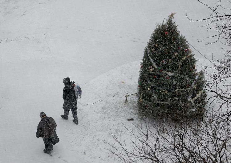 Snestorm. Folk går forbi juletræ i byen Newark i New Jersey. 