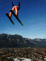 tømmermandspleje. Det er næsten meditativt at sidde i sofaen foran tv 1. januar efter nytårets udskejelser - og lade skihopperne flyve ud mod horisonten i Garmisch-Partenkirchen. 