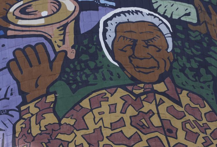 Madiba. Sydafrikanernes landsfader Nelson Mandela, kærligt omtalt Madiba, kigger her ned fra et kæmpe maleri på et køletårn i Soweto. 