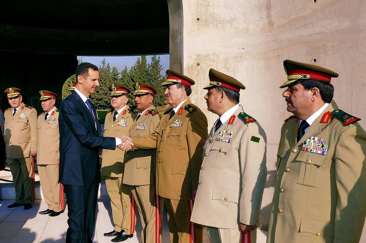 Facade. Selv om Bashar al-Assads regime er presset, er det ikke noget, man skilter med hos det syriske nyhedsbureau Sana, der f.eks. har udsendt dette foto fra en militær ceremoni i oktober 2012, hvor præsidenten hyldede officerer. 