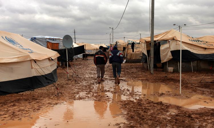 LEJRLIV. Syriske flygtninge går gennem mudderpølene i Zaatarilejren i Jordan. 