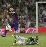 swansea-spiller? Betis' Jose Canas (liggende) tackler bolden fra Barcelonas Lionel Messi under en kamp i maj sidste år. 
