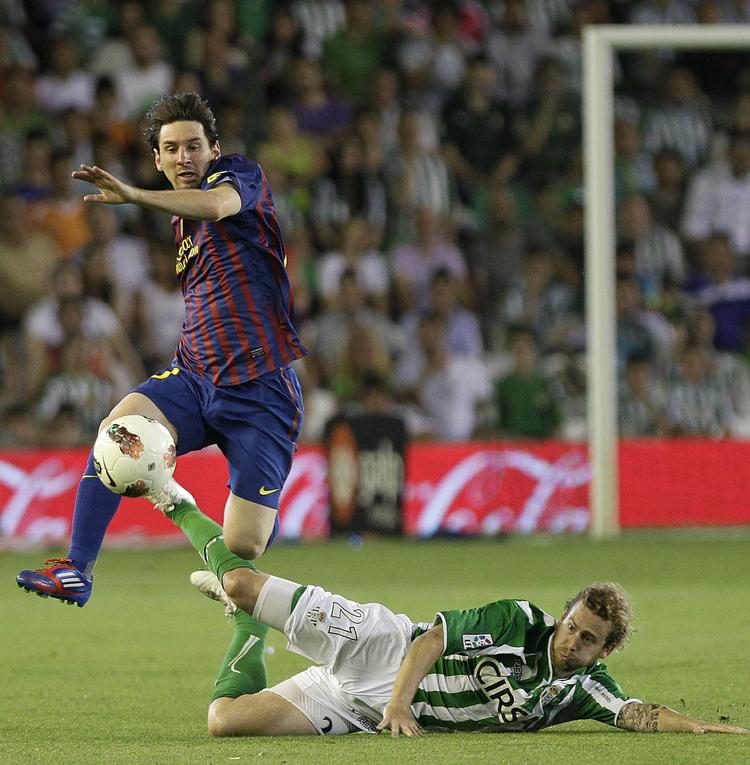 swansea-spiller? Betis' Jose Canas (liggende) tackler bolden fra Barcelonas Lionel Messi under en kamp i maj sidste år. 