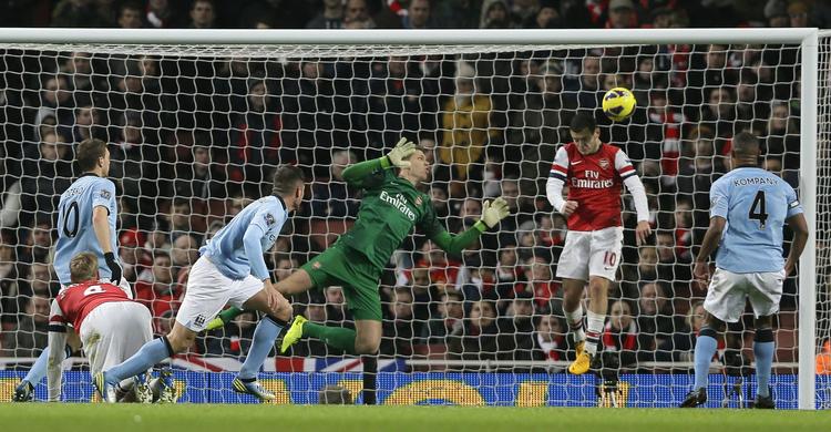 Action. Jack Wilshere får afværget en giftig City-afslutning, men kunne ikke forhindre Citys første udesejr ligaen over Arsenal i 38 år. 