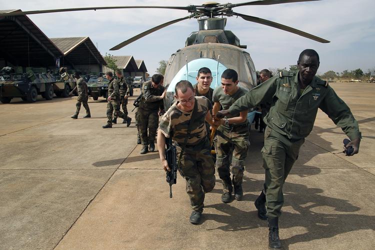pladsskabende. Franske soldater får hjælp af maliere til at fjerne en ødelagt helikopter fra en hangar, så der er plads til de franske og afrikanske soldater, som er landet eller lander i Malis hovedstad, Bamako. 