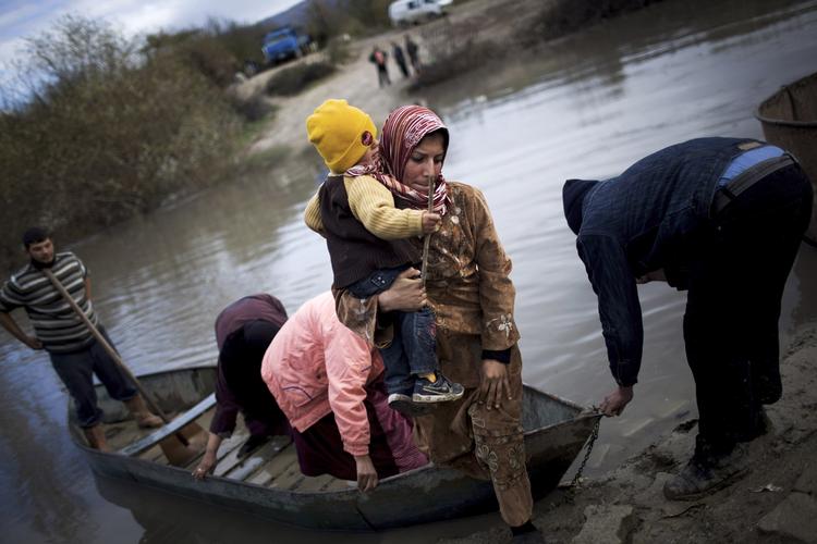 Ulykkeligt. Flygtninge bliver ved med at strømme over grænsen mellem Tyrkiet og Syrien. Her er en kvinde sejlet over en flod med sit barn. 