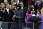 Ceremoni. Præsident Barack Obama bliver taget i ed, mens hans hustru Michelle og døtrene Malia and Sasha kigger på. 