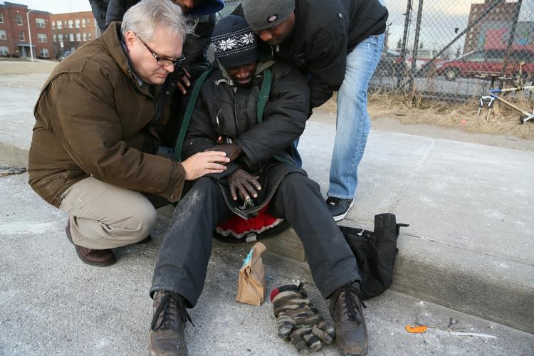 Lokale sundhedshjælpere tilser en mand i Detroit, hvis hænder er ramt af alvorlige forfrysninger. 