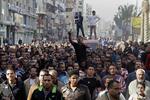 PROTEST. Tre omkomne fra weekendens demonstrationer begraves i Suez ved en højtidelighed lørdag, der illustrerer omfanget af protesterne mod styret. 